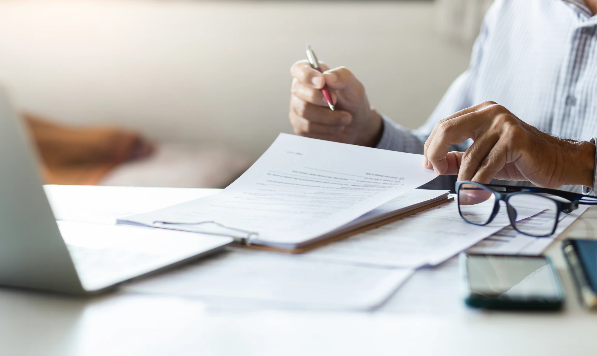 Blank insurance claim form on a clipboard with a pen on a desk