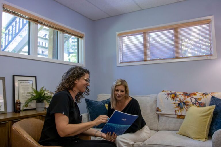 Doctor and patient talking across a desk in a bright medical office